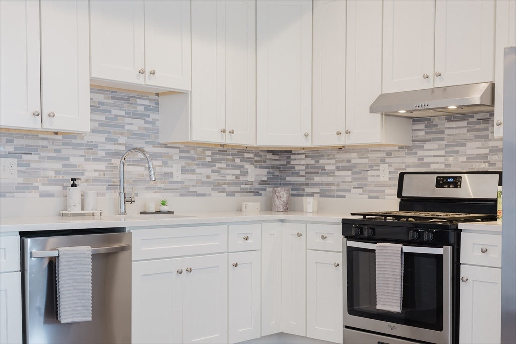 92-94 George Street, Unit 203 Boston, MA 02119 - Photo 25 of 35 a kitchen with white cabinets and white appliances
