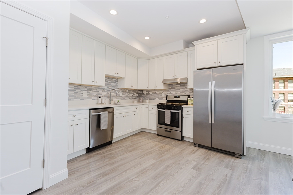 92-94 George Street, Unit 203 Boston, MA 02119 - Photo 4 of 35 a kitchen with a refrigerator sink and cabinets