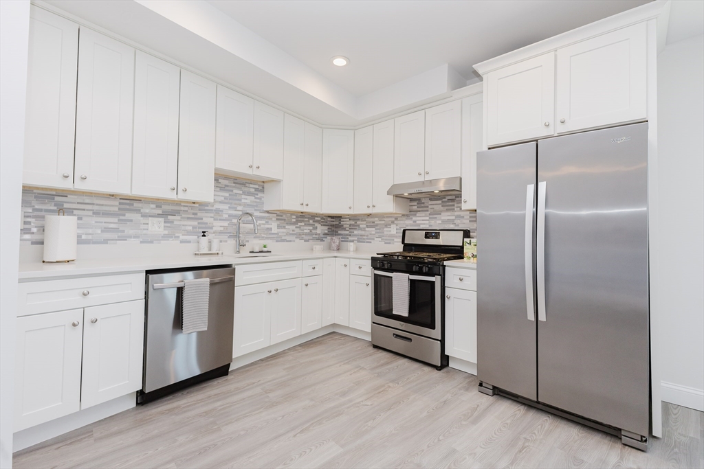 92-94 George Street, Unit 203 Boston, MA 02119 - Photo 9 of 35 a kitchen with a refrigerator stove and white cabinets
