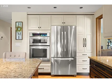 a kitchen with a refrigerator and a stove top oven