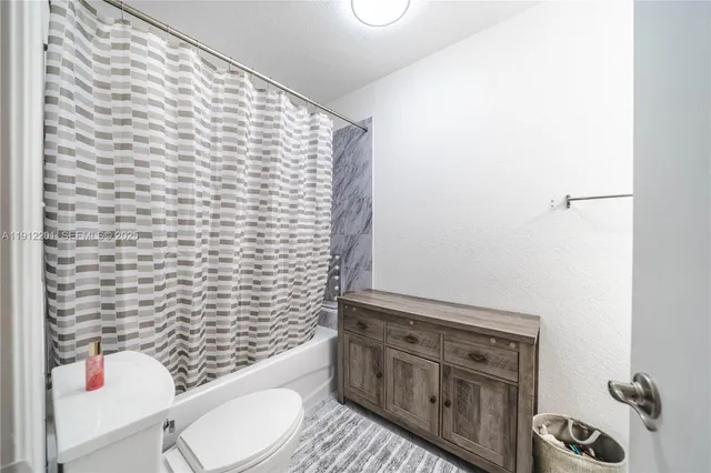 a bathroom with a toilet and a shower curtain