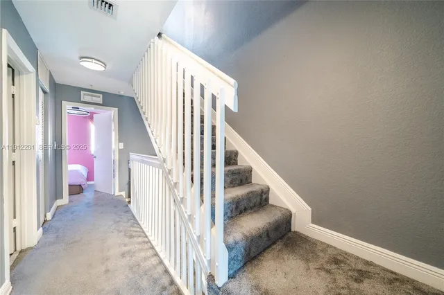 a view of a hallway with wooden floor and stairs