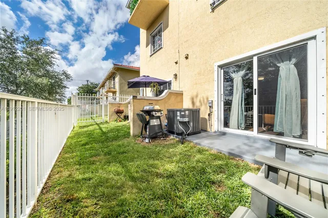 a view of a chair and table in backyard of the house
