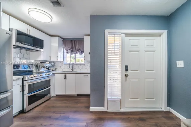 a kitchen with cabinets oven and a window