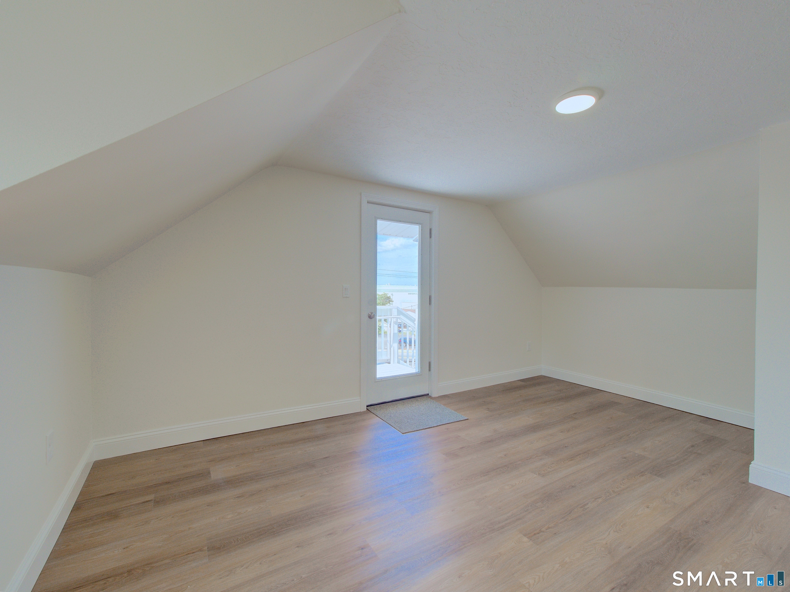 16 Benham Road, Unit D Groton, CT 06340 - Photo 13 of 15 a view of an empty room with wooden floor and window