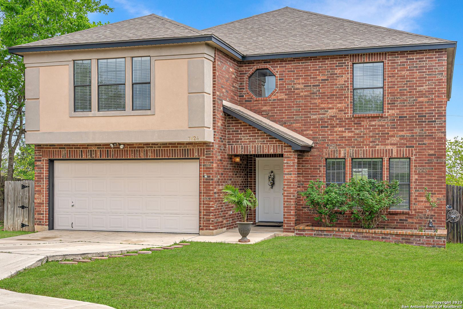 a front view of a house with a garden and plants