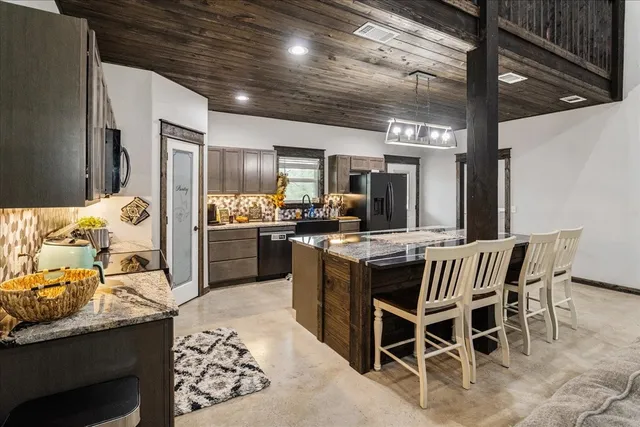 a kitchen with stainless steel appliances kitchen island granite countertop a sink and cabinets