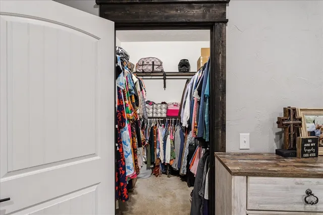 a view of walk in closet with clothes