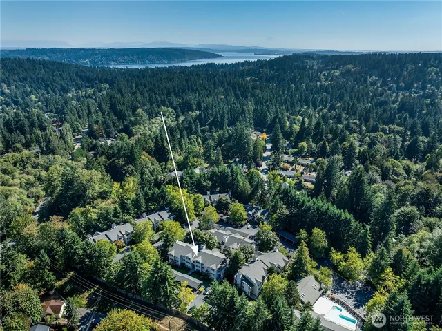 an aerial view of residential house with outdoor space and trees all around