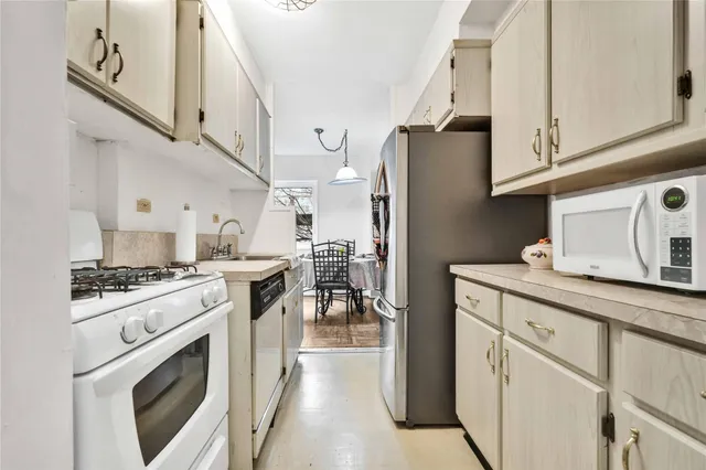 a kitchen with stainless steel appliances granite countertop a refrigerator a stove and a sink