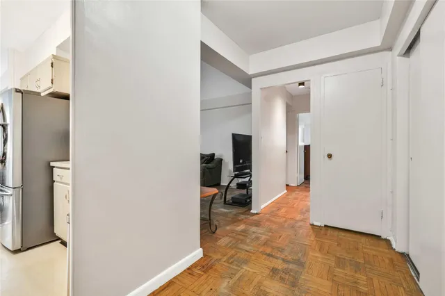 a view of a hallway with wooden cabinets and dining room