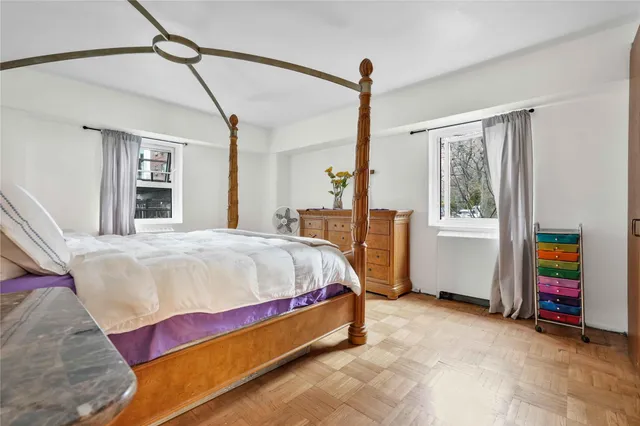 a bed sitting in a spacious bedroom next to a window