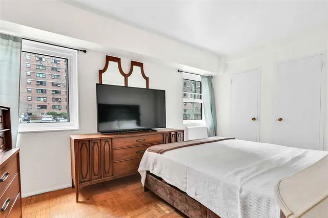 a bedroom with a bed and a flat screen tv