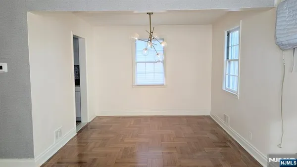 a view of an empty room with window and stairs