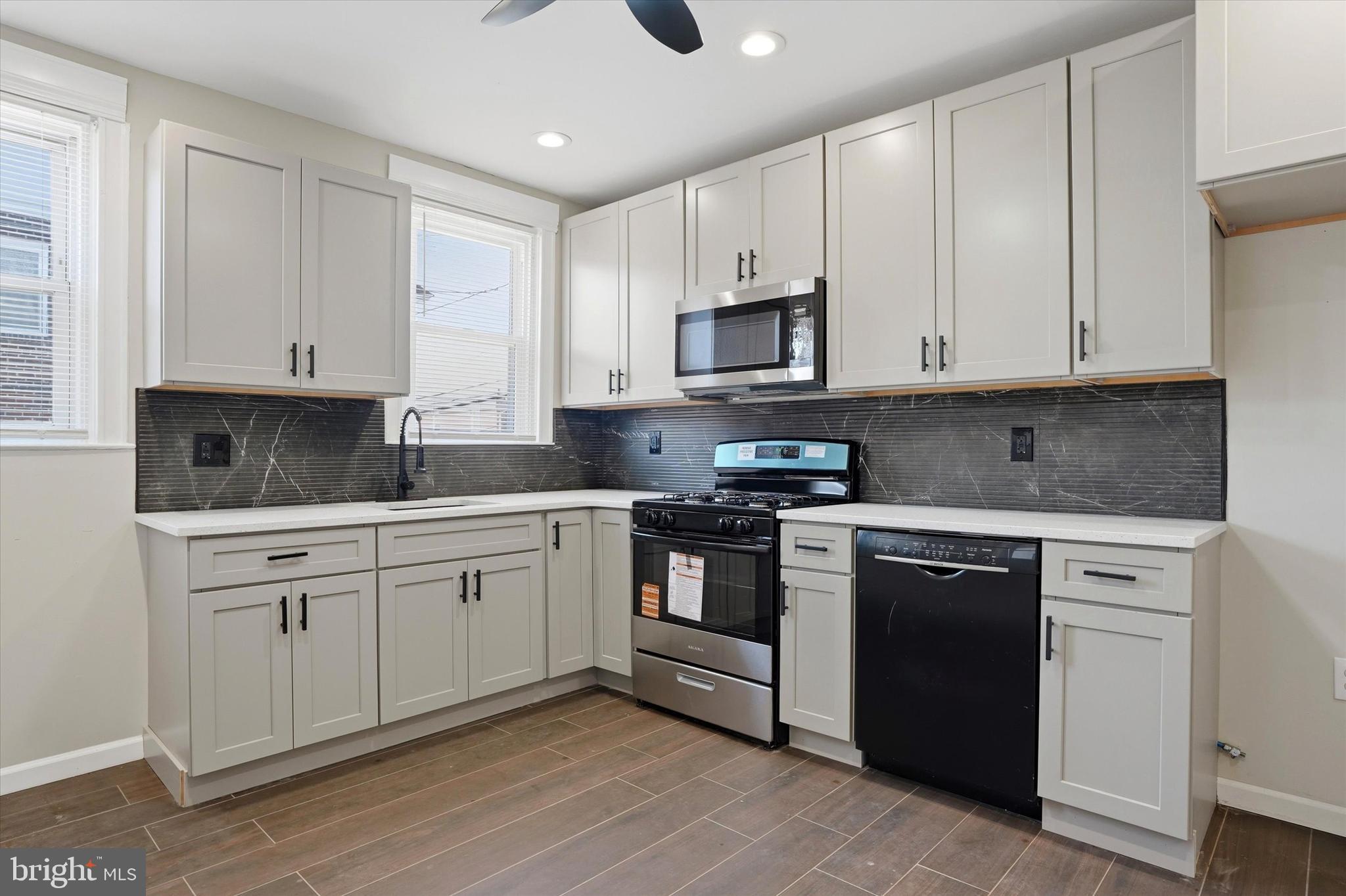 6258 Magnolia Street Philadelphia, PA 19144 - Photo 12 of 25 a kitchen with granite countertop white cabinets and stainless steel appliances