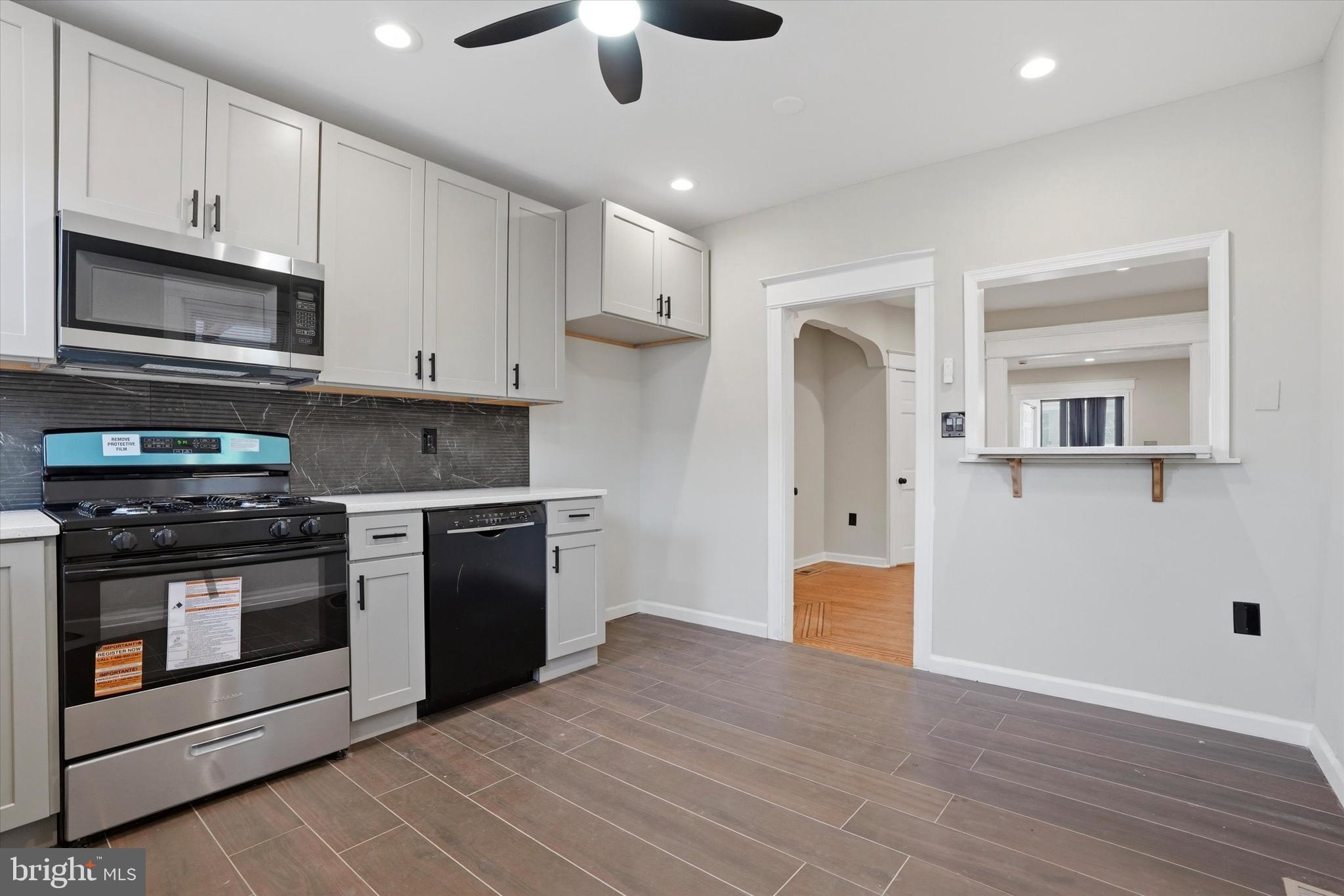 6258 Magnolia Street Philadelphia, PA 19144 - Photo 13 of 25 a kitchen with stainless steel appliances granite countertop a stove and a refrigerator