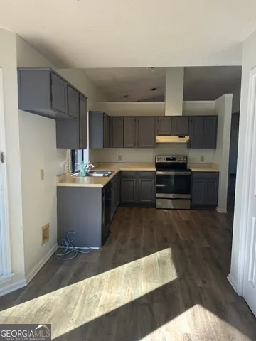 a kitchen with a sink and steel appliances