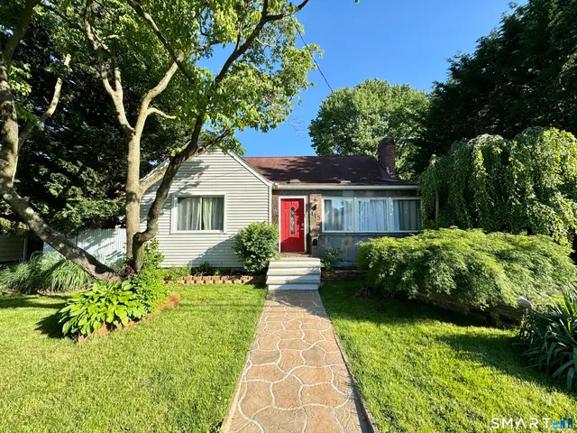 a front view of a house with a garden and plants