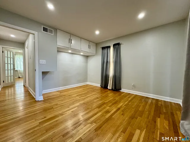 a view of empty room with wooden floor