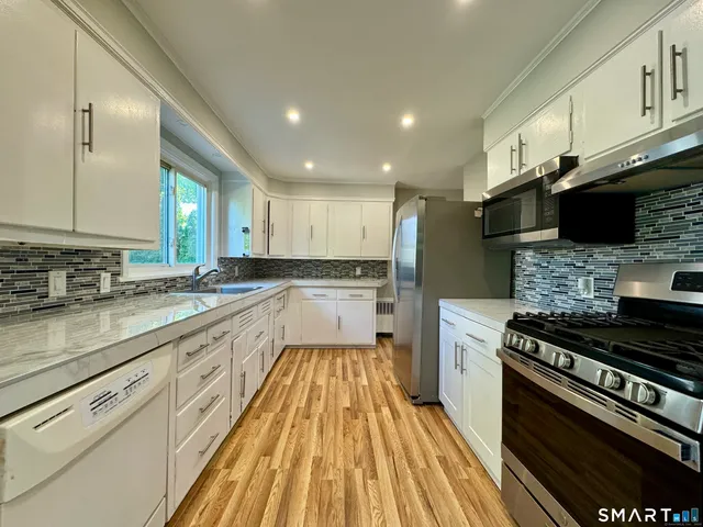 a kitchen with a sink stove top oven and cabinets