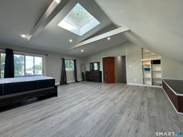 a view of empty room with wooden floor and window