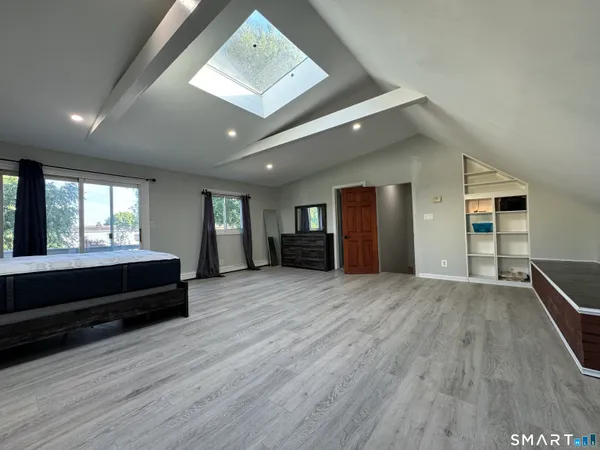 a view of empty room with wooden floor and window