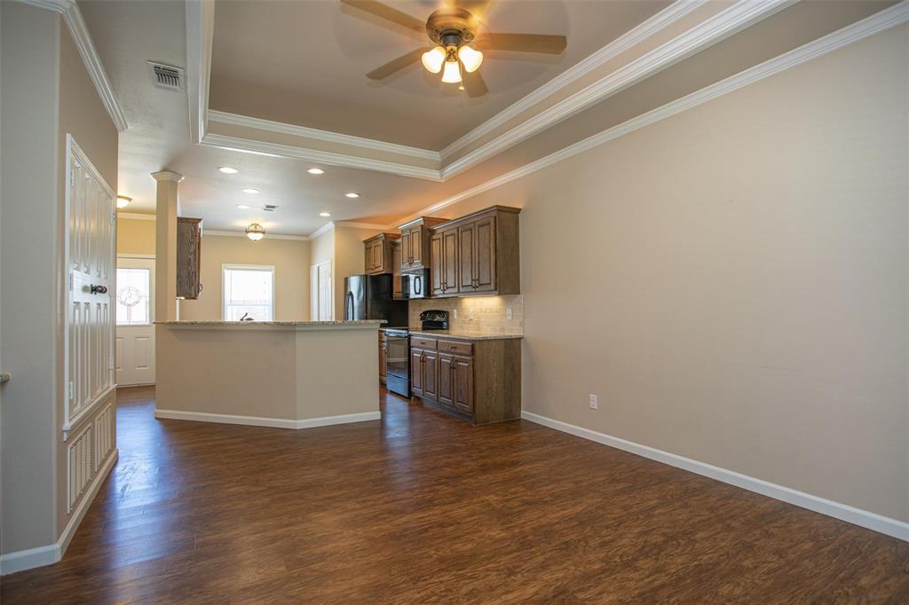 455 Neals Hill Road Oak Ridge, TX 76240 - Photo 7 of 19 Kitchen featuring range with electric cooktop, crown molding, tasteful backsplash, dark wood-type flooring, and dark brown cabinetry
