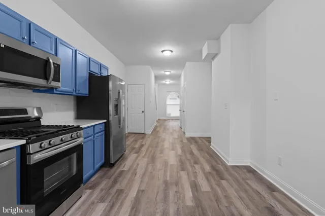 a view of kitchen with wooden floor and electronic appliances