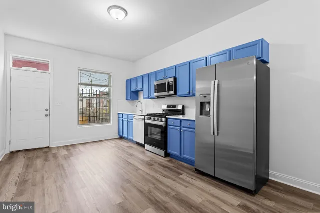 a kitchen with stainless steel appliances a refrigerator and a stove top oven