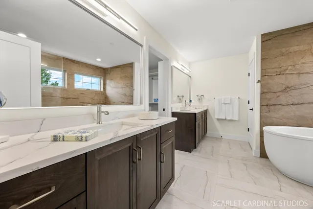 a bathroom with a double vanity sink a toilet a mirror and bathtub