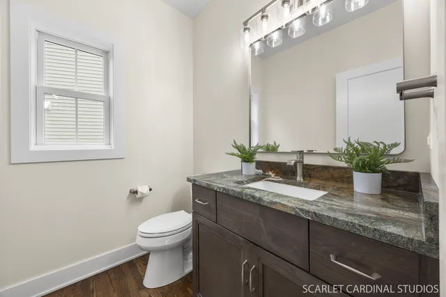 a bathroom with a granite countertop sink a toilet and mirror