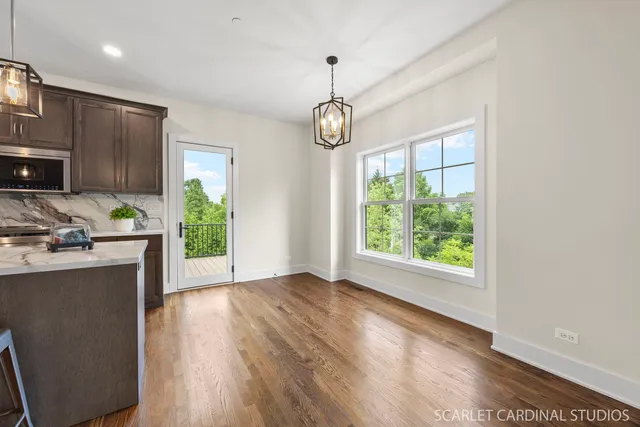 a view of a kitchen with furniture a ceiling fan and wooden floor