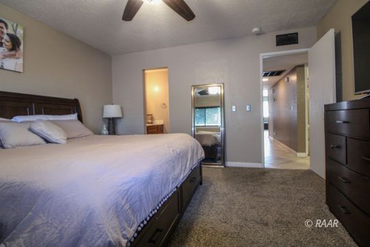 221 South Primrose Street Ridgecrest, CA 93555 - Photo 21 of 29 a bedroom with a bed and a chandelier