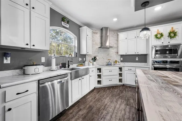 a kitchen with granite countertop a sink window and stainless steel appliances