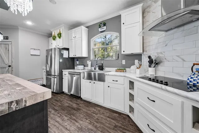 a kitchen with white cabinets sink and stainless steel appliances