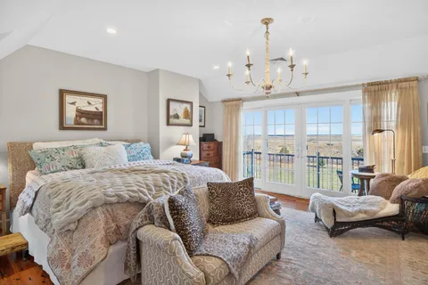 a spacious bedroom with a bed a couch and a view of kitchen