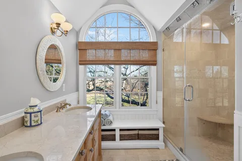a bathroom with a tub and a large mirror