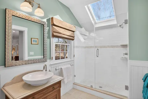 a bathroom with a granite countertop sink mirror and a shower