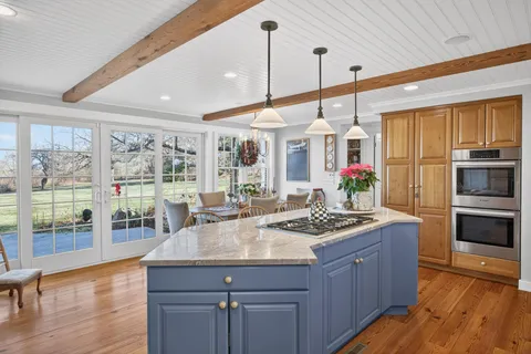 a kitchen with a stove a refrigerator a sink and dishwasher with wooden floor
