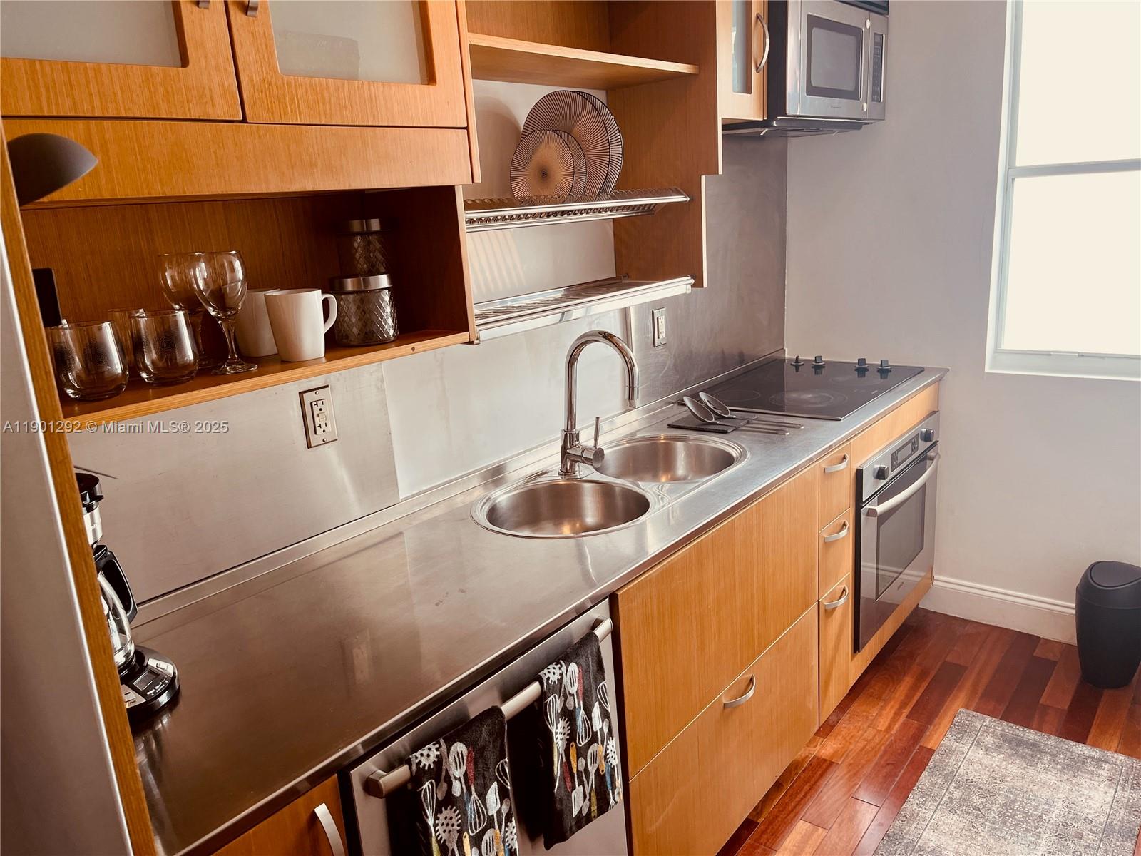 1340 Drexel Avenue, Unit 406 Miami Beach, FL 33139 - Photo 19 of 34 a kitchen with stainless steel appliances granite countertop a sink and a stove