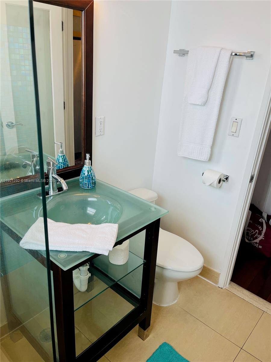 1340 Drexel Avenue, Unit 406 Miami Beach, FL 33139 - Photo 26 of 34 a bathroom with a sink toilet and mirror