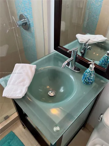 a bathroom with a granite countertop sink a toilet and a mirror