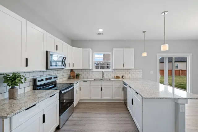 a kitchen with stainless steel appliances granite countertop sink stove and cabinets