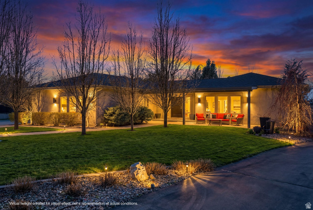 View of front of house featuring a lawn, outdoor furniture, a patio area, and stucco siding