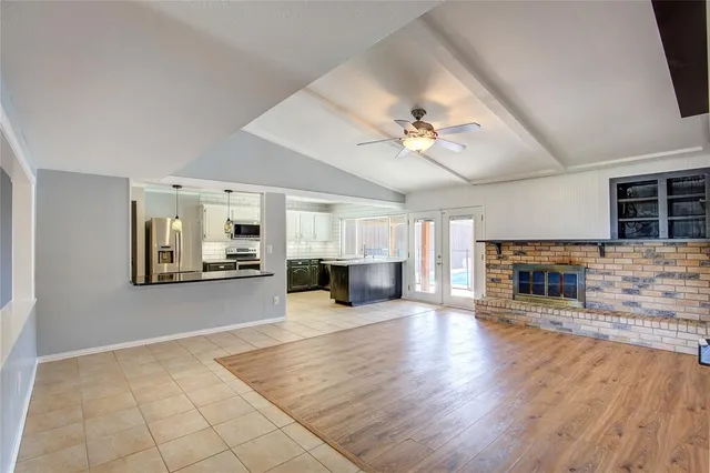 a view of a livingroom with a fireplace a chandelier and wooden floor