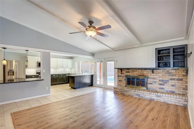 a living room with stainless steel appliances kitchen island granite countertop furniture and a fireplace