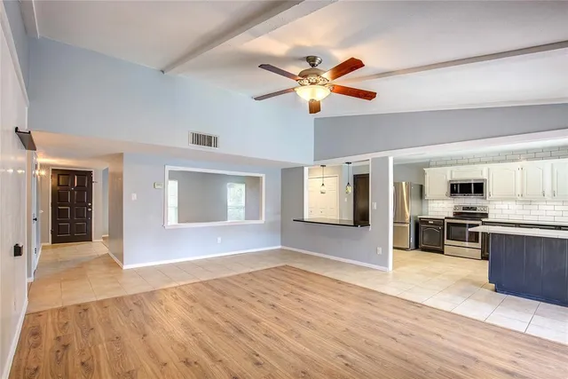 a view of a livingroom with kitchen and appliances