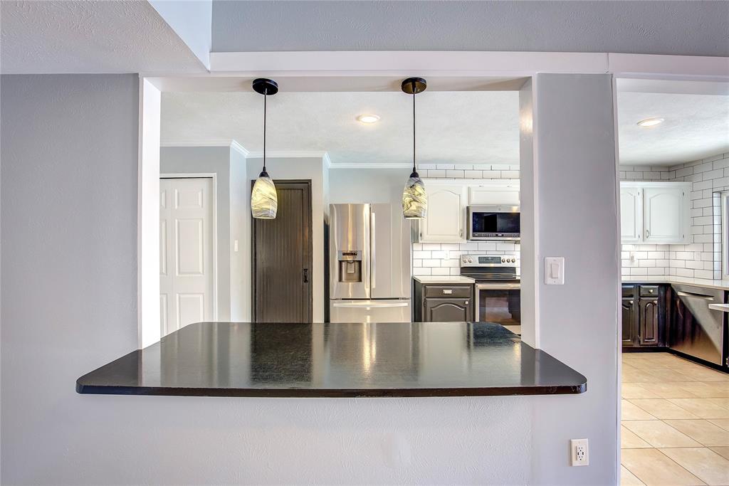 5233 Reed Drive The Colony, TX 75056 - Photo 17 of 40 a kitchen with kitchen island a counter top space a sink stainless steel appliances and cabinets