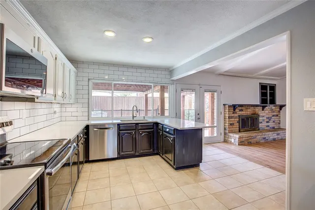 a large kitchen with granite countertop a stove top oven a sink a counter space and cabinets