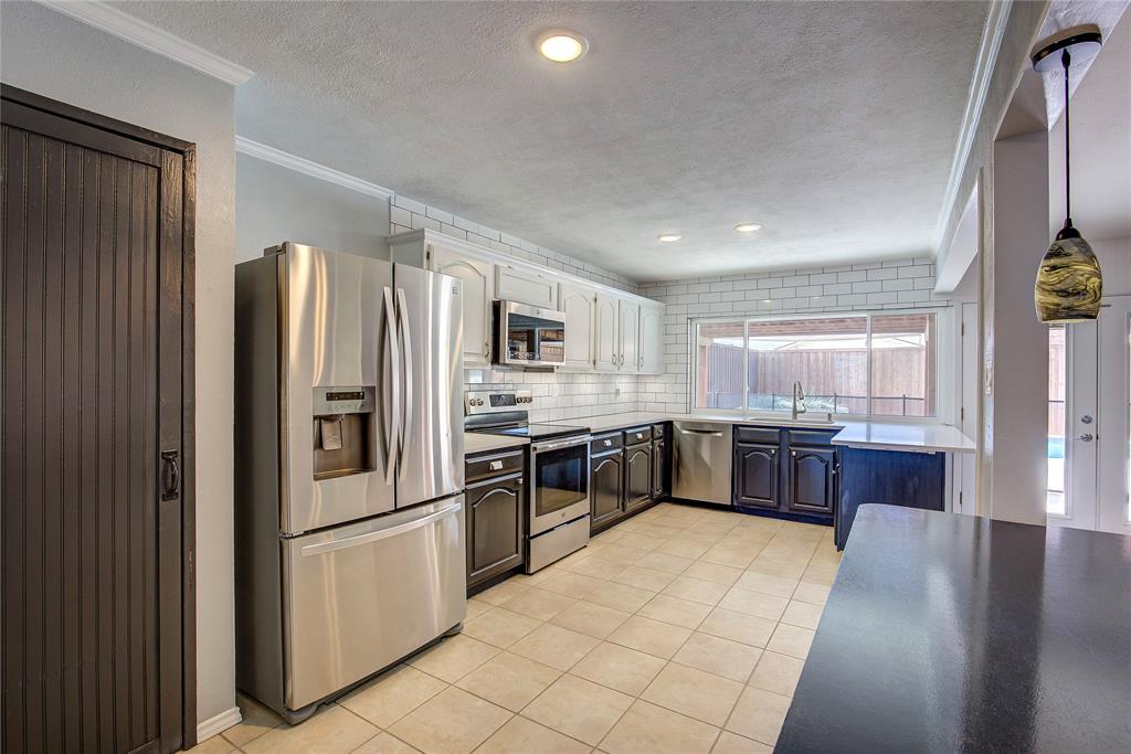 5233 Reed Drive The Colony, TX 75056 - Photo 24 of 40 a large kitchen with a large window and stainless steel appliances